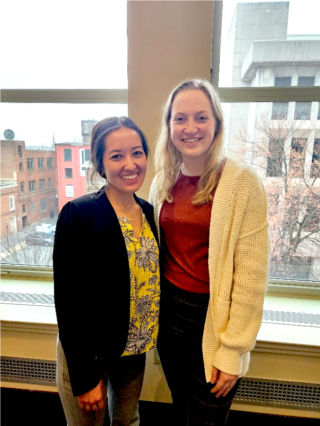 Alyssa Mekel and Annie Weyand stand in front of a window