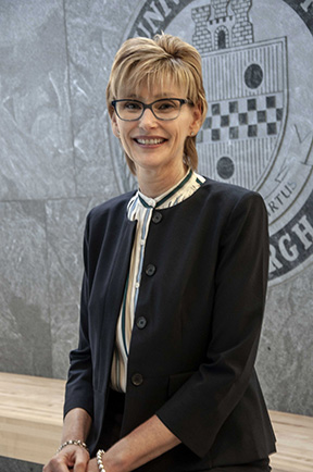 Susan Meyer in front of University of Pittsburgh seal