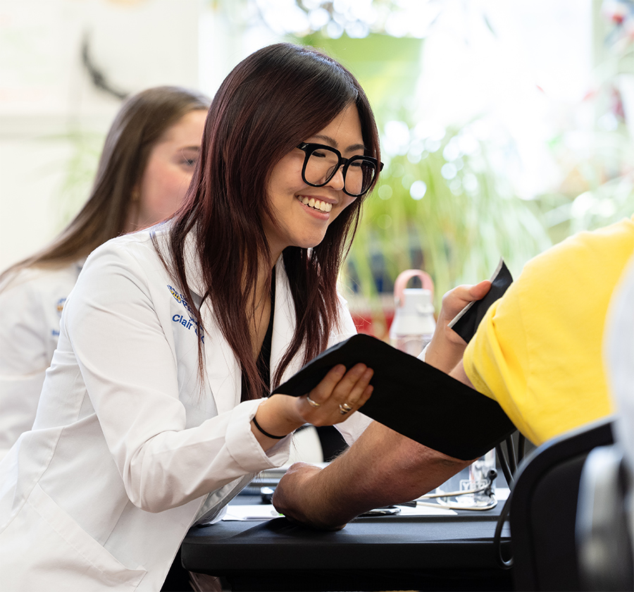 Student conducting a blood pressure exam.