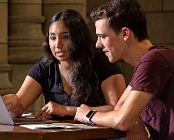 Two people in front of a laptop